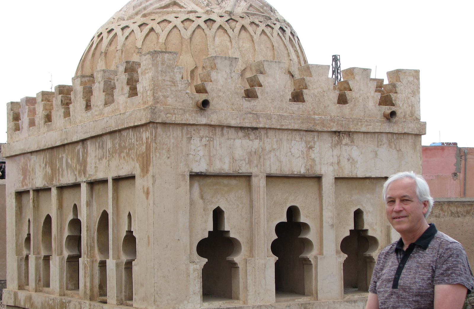 Evans Harrell standing beside an ornately carved stone building