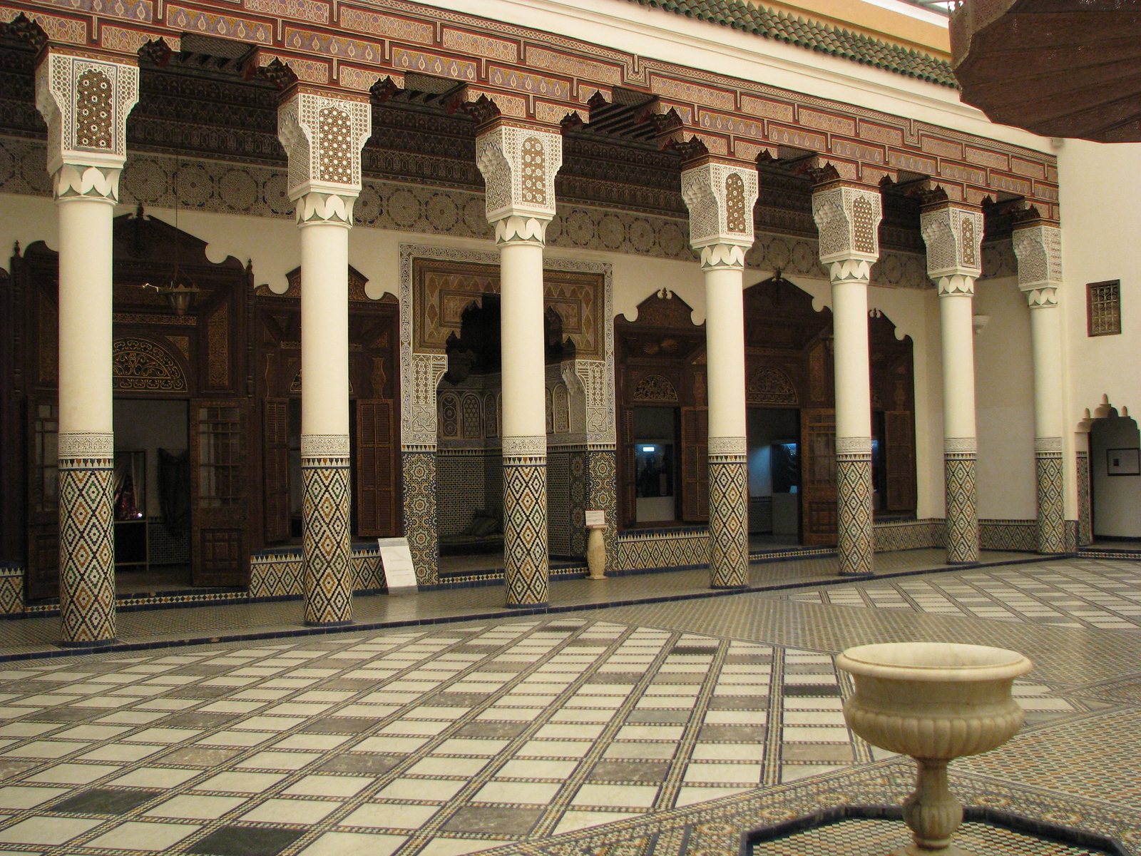 A colonnaded courtyard with carved capitals and tiled floor
