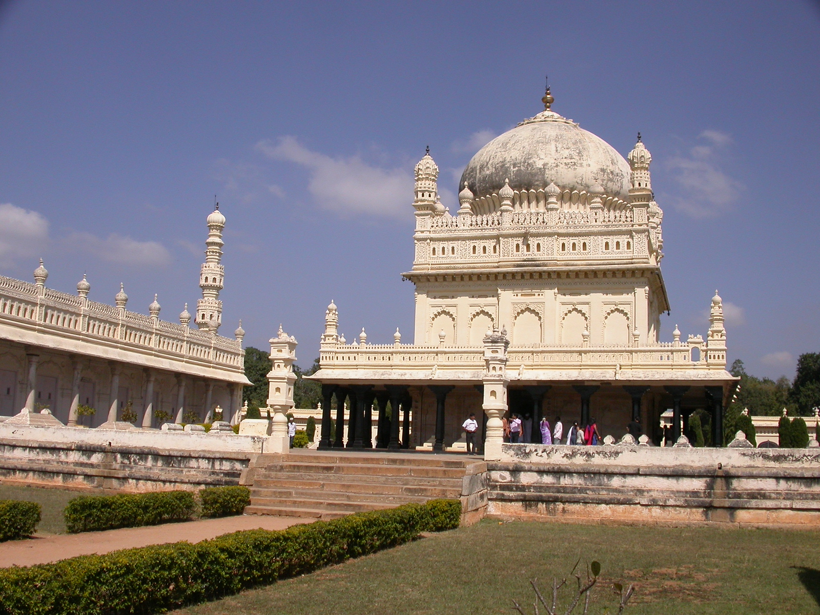 A white domed mausoleum with minarets set in formal gardens